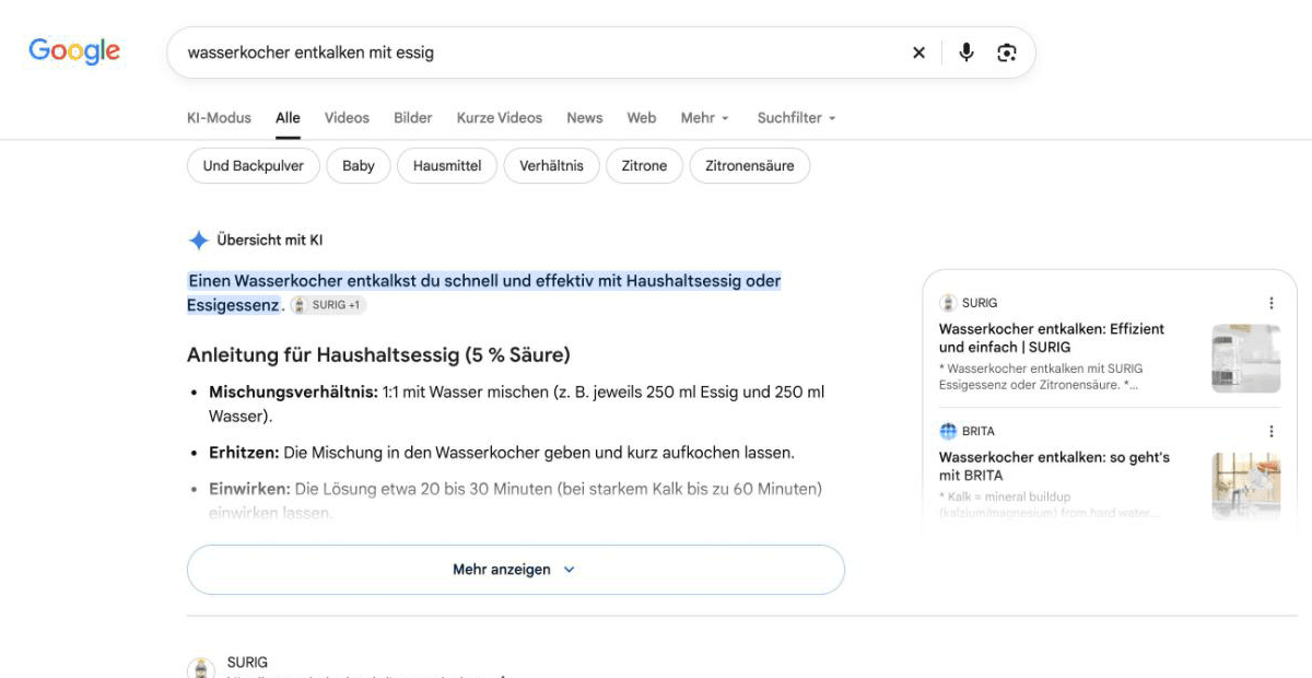 Google-Suche auf google.de nach wasserkocher entkalken mit essig: In der Tab-Leiste stehen KI-Modus, Alle, Videos, Bilder, Kurze Videos, News, Web und Mehr; darunter zeigt Google eine Übersicht mit KI mit dem Button Mehr anzeigen.